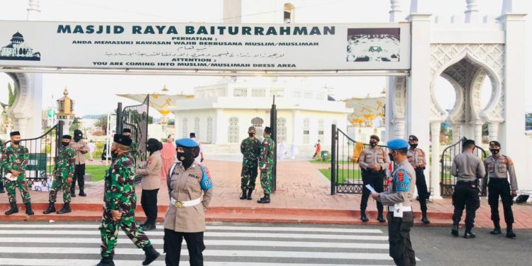 Satpol PP/WH, Polri dan TNI bagi Masker kepada Jamaah Shalat Ied di MRB