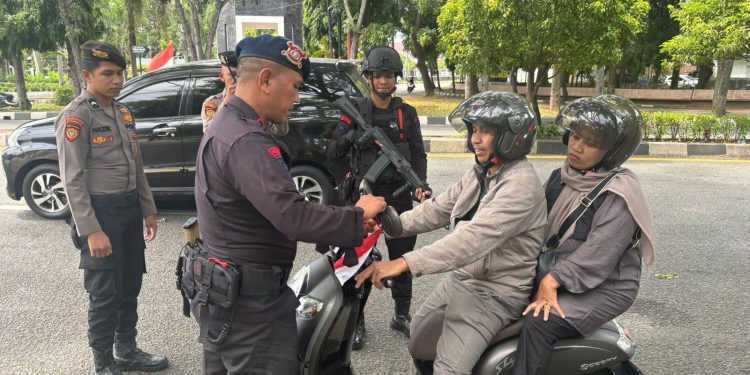 Tim Patroli KRYD Polda Aceh Pasang Bendera Merah Putih pada Kendaraan Warga